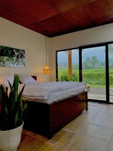 a bedroom with a large bed and a potted plant at Tropical Aurora Tetebatu in Tetebatu +44 photos