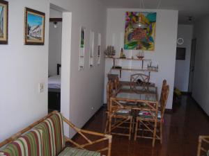 a living room with a dining room table and chairs at Condominio Edifício Las Vegas in Guarujá