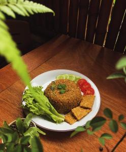 a plate of food on a table with lettuce and tomatoes at Tropical Aurora Tetebatu in Tetebatu