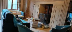 a living room with a couch and a fireplace at Aux 10 Ponts Maison spacieuse et conviviale au bord de la Somme la mer à 30 min 6 personnes in Pont-Rémy
