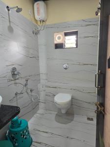 a white bathroom with a toilet and a sink at Ocean Mist Beach Homestay in Māvalli