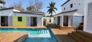 a house with a swimming pool next to a house at Paradise City Break in Saint-Pierre