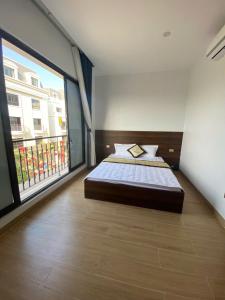 a bedroom with a bed and a large window at Hola Hotels Móng Cái in San Cap