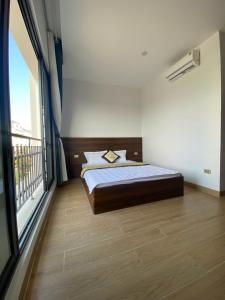 a bedroom with a bed and a large window at Hola Hotels Móng Cái in San Cap