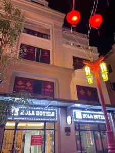 a building with a sign in front of a store at Hola Hotels Móng Cái in San Cap