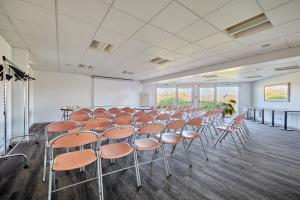 a room with rows of chairs in a room at CIT'HOTEL Armony Hotel in Bourg-Achard