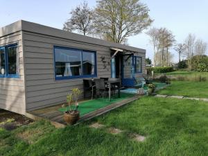 a tiny house with a table in a yard at Tinyhouse CARPE DIEM in Dirkshorn