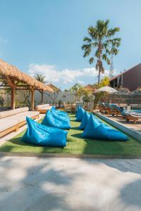 a row of blue pillows on the grass near a pool at Lay Day Gili T in Gili Trawangan