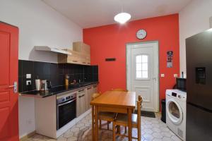 a kitchen with a table and a washing machine at Sweet garden in La Fère