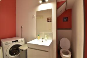 a bathroom with a sink and a washing machine at Sweet garden in La Fère +4 photos