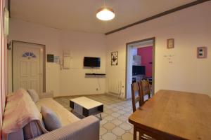 a living room with a couch and a table and a dining room at Sweet garden in La Fère
