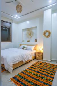 a bedroom with a large bed and a rug at The Palm Surfhouse in Tamraght Ouzdar +87 photos