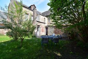 a table and chairs in the yard of a house at Sweet garden in La Fère