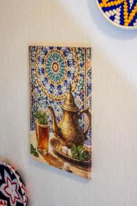 a painting of a teapot on a wall at The Palm Surfhouse in Tamraght Ouzdar