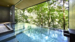 a swimming pool in a house with a view of trees at Hatsuhana in Hakone