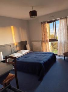 a bedroom with a bed and a large window at Hotel La Planquette in Réquista