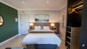 a bedroom with a large bed and a green wall at Studio Bella Vista Plett in Plettenberg Bay +37 photos
