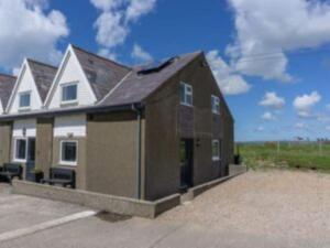 a large house with a garage in a parking lot at Rhiw in Llangian