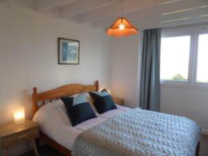 a bedroom with a large bed and a window at Rhiw in Llangian