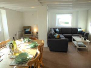 a living room with a table and a couch at Rhiw in Llangian