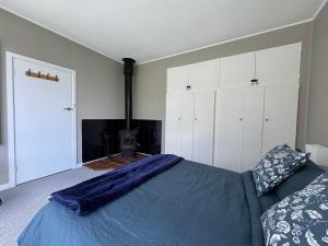 a bedroom with a bed and white cabinets at Sunset View House - Rustic Outdoor Bathhouse, Walk to Town in Warburton +18 photos