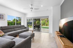 a living room with a couch and a tv at 1 Seaspray Avenue in Coolum Beach