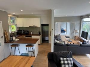 a kitchen and living room with a couch and a table at Sunset View House - Rustic Outdoor Bathhouse, Walk to Town in Warburton