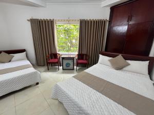 a bedroom with two beds and a table and chairs at An Phú Stay & Coffee in Cửa Lô +6 photos