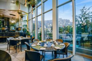ein Restaurant mit Tischen und Stühlen und Blick auf die Apostel in der Unterkunft The Capital 15 on Orange Hotel & Spa in Kapstadt
