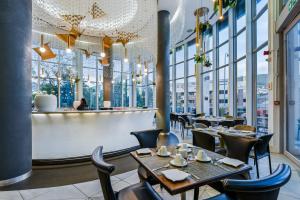 ein Restaurant mit Tischen, Stühlen und Fenstern in der Unterkunft The Capital 15 on Orange Hotel & Spa in Kapstadt