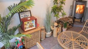 a room with plants and a tv and a fireplace at Green Soochaehwa Pension Yangyang in Yangyang