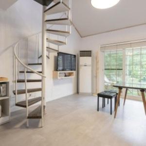 a living room with a spiral staircase and a table at Green Soochaehwa Pension Yangyang in Yangyang +7 photos