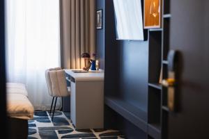 ein Badezimmer mit Waschbecken und einem Tisch mit Stuhl in der Unterkunft Hotel Soho - Renovated 2026 in Tartu