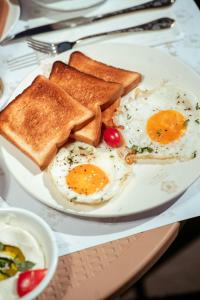 a plate of eggs and toast on a table at Hotel Palmera Inn in Pune