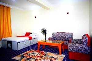 a room with a bed and a chair and a table at Kattel Homestay and Apartments in Bālāju