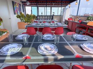 a long table with red chairs and plates on it at Habitación individual con baño privado a 3 Min del Estadio Azteca-Banorte y muy cerca de zona de hospitales in Mexico City