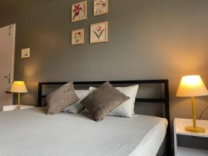 a bedroom with a bed with pillows and two lamps at HO6 Homestay in Guwahati