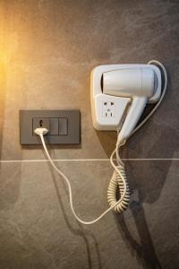 a white hairdryer hanging on a wall at Dhulikhel Mountain Resort in Dhulikhel