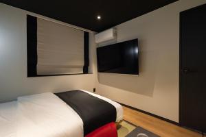 a bedroom with a bed and a flat screen tv at Mitasuya Ryokan Hotel by Anook Gwangju in Gwangju