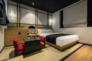 a bedroom with a bed and a chair and a mirror at Mitasuya Ryokan Hotel by Anook Gwangju in Gwangju