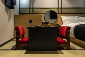 a bedroom with a bed and a desk and a mirror at Mitasuya Ryokan Hotel by Anook Gwangju in Gwangju