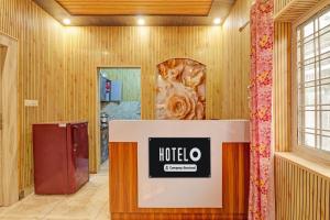 a hotel lobby with a hotel sign on a counter at Super Hotel O Sahastradara Road Dehradun Formerly Kriswa Home in Dehradun
