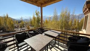 a patio with tables and chairs on a balcony at Overland Heights - Near Leh Airport in Leh