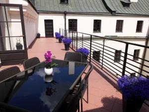 einen Balkon mit einem Tisch, Stühlen und lila Blumen in der Unterkunft Dom na Podwalu in Lublin