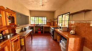 a kitchen with wooden cabinets and a counter top at Tuncosurfhouse in El Sunzal