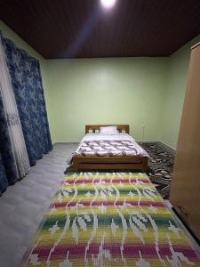 a bedroom with a bed with a colorful rug on the floor at Ikamba Residence in Rwamagana