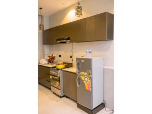 a kitchen with a refrigerator and a stove at Residency by Mozette Kigali in Kigali