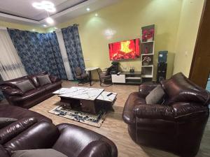 a living room with leather furniture and a flat screen tv at Ikamba Residence in Rwamagana