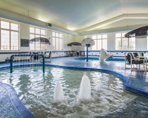 a swimming pool with a fountain in the water at Comfort Inn & Suites Madison North in De Forest