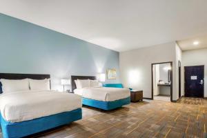 a hotel room with two beds and a bathroom at MainStay Suites Winfield-Teays Valley in Hurricane +30 photos